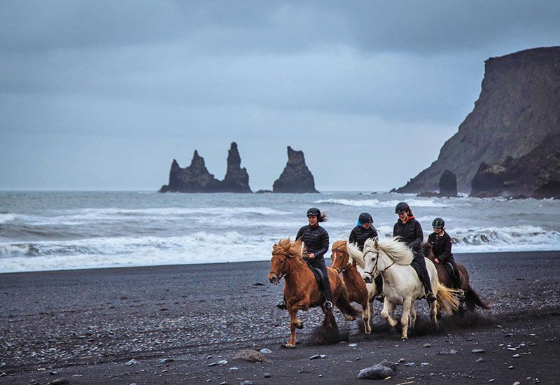 Paseo a caballo en playa negra